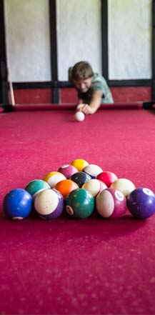 Ein junger Billiarspieler steht am Billiardtisch